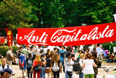 A banner reading "Anti Capitalista" is shown in the same color and fonts used in the Coca Cola branding