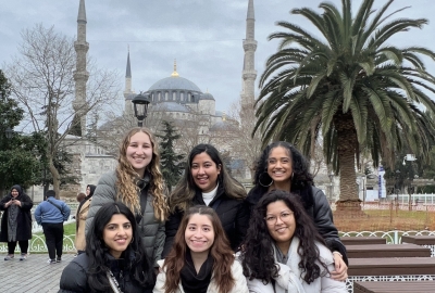 Six students sit in front of the Blue Mosque in Istanbul, Turkiye