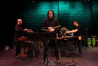 Three percussionists on stage performing