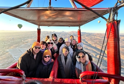 A group of smiling students pose in a hot air balloon in Cappadocia