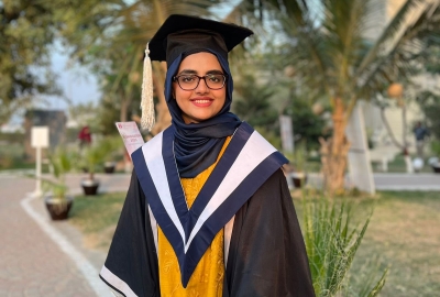 woman in cap and gown smiling