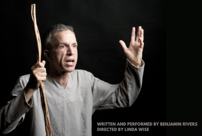 Man standing with shocked look on his face holding up a stick