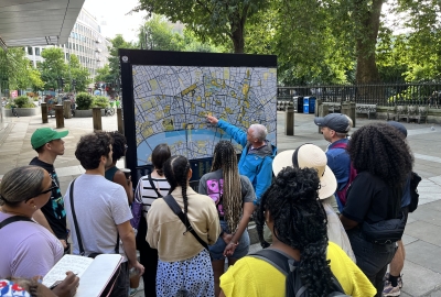 Students and an instructor gather around a city map