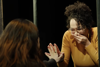 Two drama therapy students laughing as they complete a mirroring exercise. 