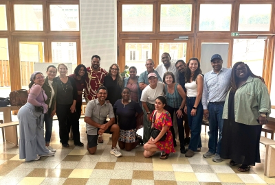 A group of NYC teachers poses in front of a wall of windows