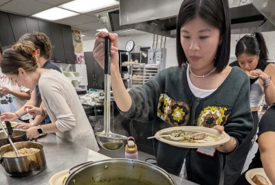 Students labeling soup out of a pot.