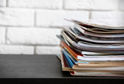 A stack of publications sits on a desk.