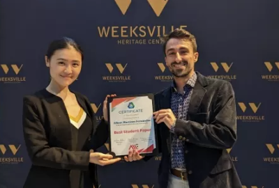 Two students holding up a shared award