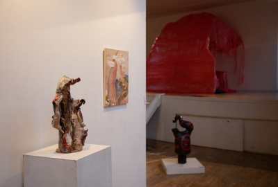 Two abstract sculptures and a painting on display in a gallery.