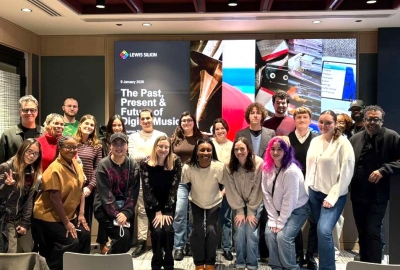 Students and faculty stand together for a group photo inside the Lewis Silkin office after a guest lecture, smiling toward the camera. 