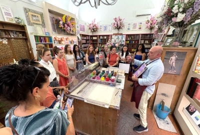 Students watch a painting demonstration in a store in Florence