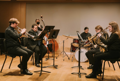 Group of students practicing brass, bass and drums in studio