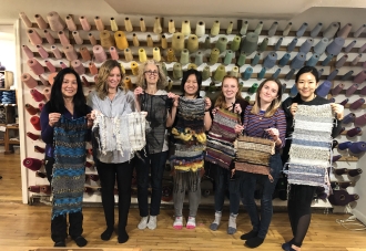 Students with weaving in front of wall of thread.