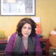 A screenshot from Jayanthi's YouTube series on creativity under constraints. She sits in front of a table with organized art supplies on top.