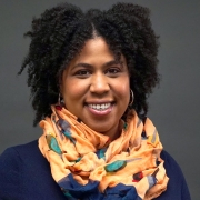A headshot of Dr. Stephanie Cook wearing an orange scarf