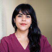 Headshot of NYU Metro Center's Flor Khan. Image features a woman leaning against a column, looking straight ahead