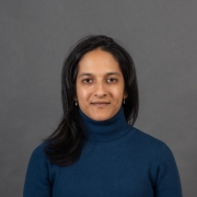 South Asian woman with black hair and a blue sweater