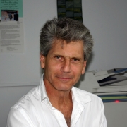 Portrait of Gerald Pryor. He is wearing a white button down shirt and looking directly at the camera.