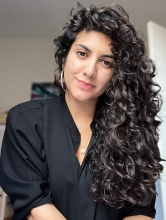 Headshot photo of Silvia with her curly hair