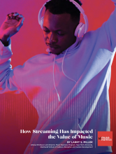 Young man dancing with headphones on cover of paper by Professor Larry Miller