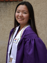Joyce Chung smiles at the camera. She is dressed in her academic regalia.