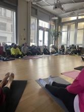 A group of people sitting in a circle on yoga mats.