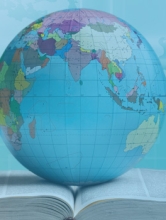 Stock Image of a globe resting on a book