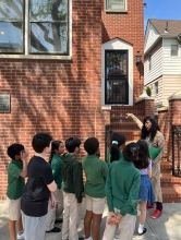 Charanya talks to a group of students in front of the house