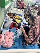 Babies lay on hospital beds while people attend to them
