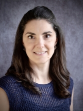 This is a headshot of a caucasian woman with shoulder length brown hair.