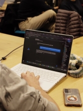 A student looks at his computer screen which shows an AI conversation with blue chat boxes