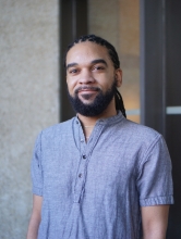 Person looking at camera, soft smile, visible from their waist up