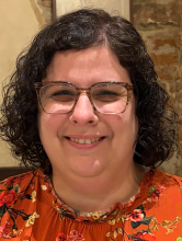 Daphna Harel: woman with brown curly hair wearing glasses