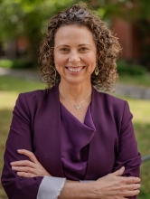 Woman with curly hair wearing purple blazer