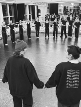 A circle of dancers in a dance studio, varying in age from children to adults