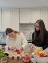 Lily Osman and her mother cutting vegetables in a kitchen