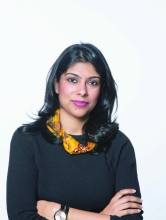 Manjari Sihare-Sutin, an Indian woman in a black shirt with a colorful scarf, looks into the camera with her arms crossed.