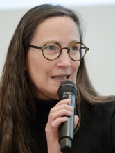 Dr. Raphaela Henze speaking into microphone