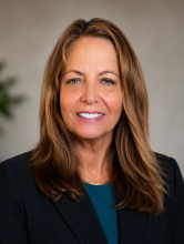 professionally dressed woman smiling into camera