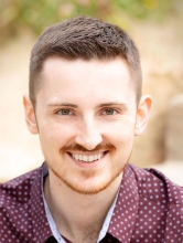 Headshot of Hunter Hanson wearing a red button up shirt with blue dots