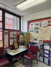 A classroom with posters and a desk