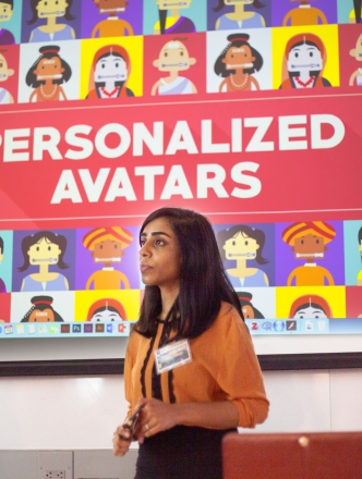 A graduate student presenting her work in front of a large digital display