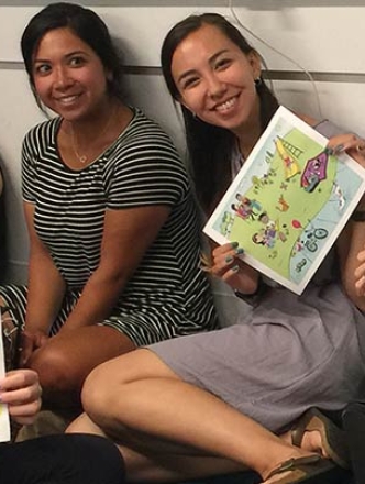 Students holding up sheets of paper used to conduct activities and research in the lab.