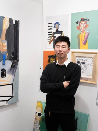 BFA student in studio with paintings.