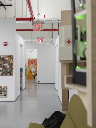A picture of the hallways of the BFA art studios. Some paintings appear on the wall to the left of the image.