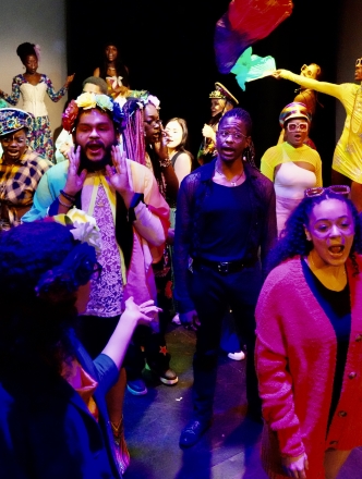 NYU students, large group in colorful costumes on stage