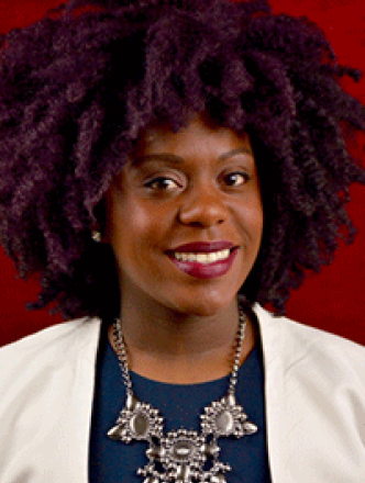 Dr. Chantal Hailey smiles in front of a red backdrop. 