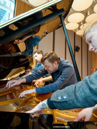 five students examining inside of a grand piano