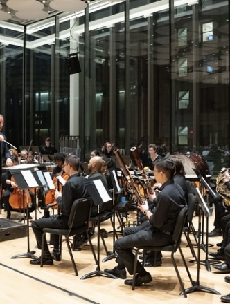 NYU orchestra performing with conductor Ted Sperling