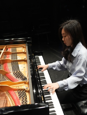 Woman playing grand piano with a view of the inside of the piano